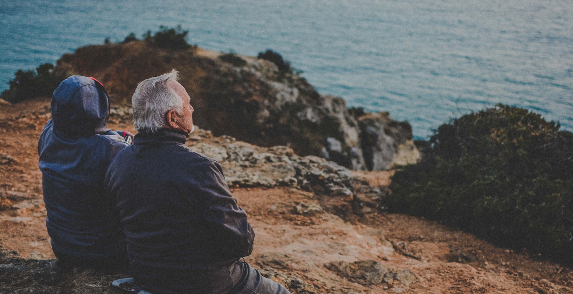 couple sitting outdoors overlooking sea