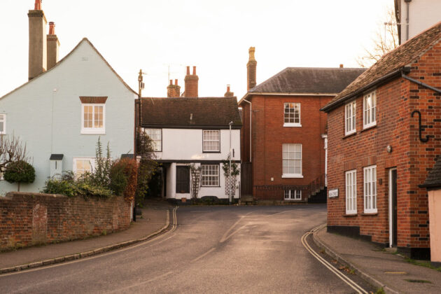 A small group of terrace houses on a typical looking british street.